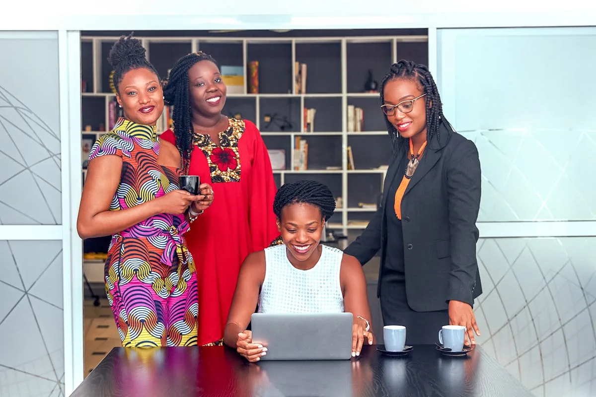 African women professionals collaborating around a laptop