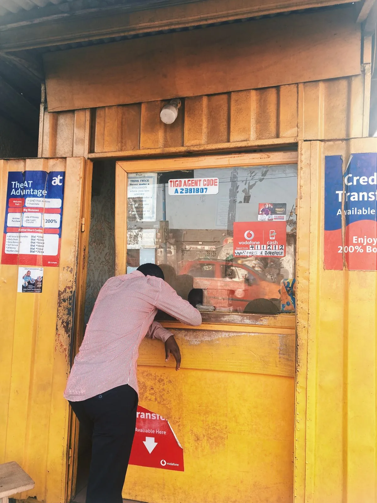 An African small-business owner at her market stall taking a mobile order