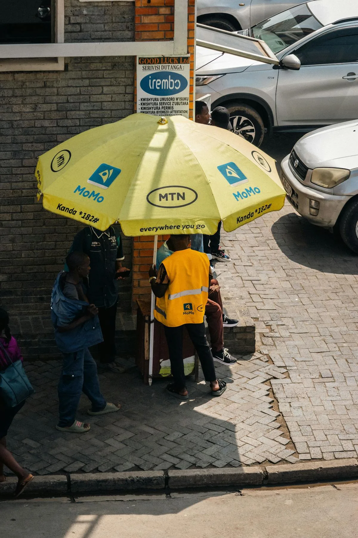 A mobile money agent serving customers at a street kiosk in Africa